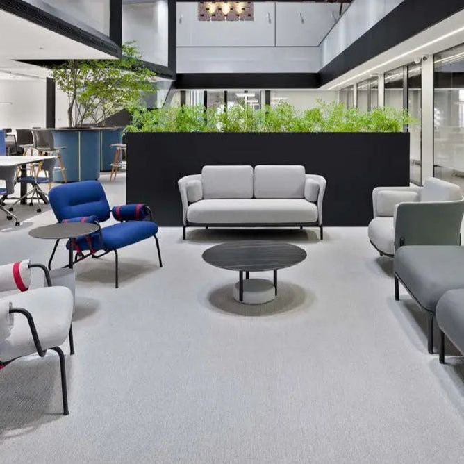 Modern office lounge area with gray and blue seating arrangements.