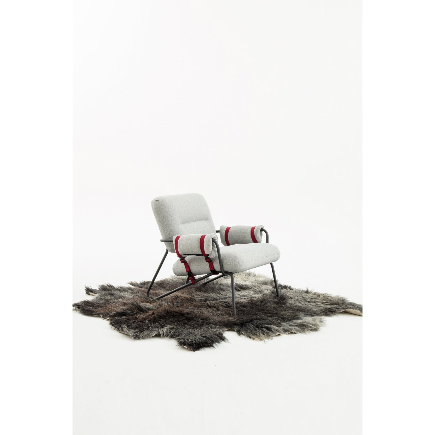 White upholstered armchair with red metal frame and chrome legs.