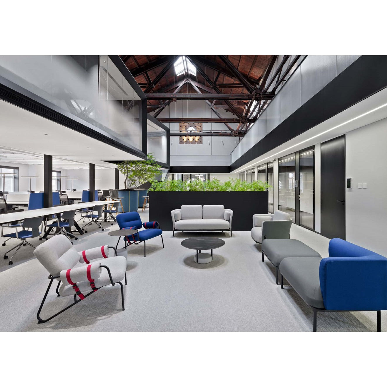 Modern office lounge area with gray and blue seating arrangements.