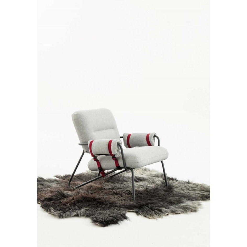 Modern white armchair with red striped cushions and metal legs.